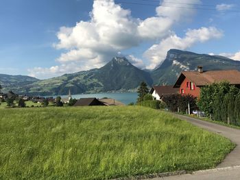 Scenic view of field and houses against sky