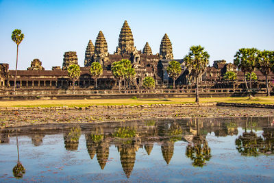 Reflection of temple in pond against building