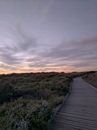 View of boardwalk against sky during sunset