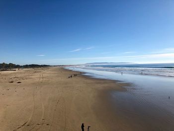 Scenic view of beach against blue sky