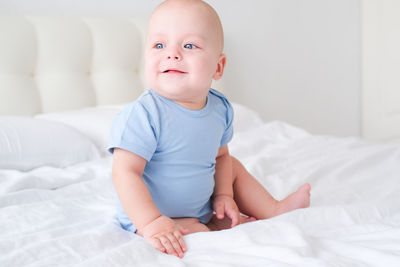 Cute baby boy sleeping on bed at home