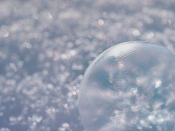 Close-up of crystal ball against sky