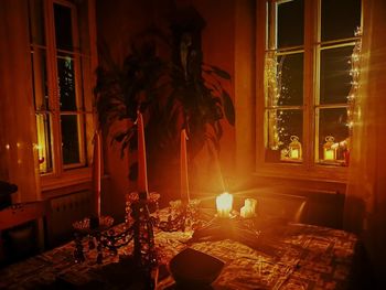 View of lit candles on table at home