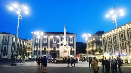 People on city street against blue sky