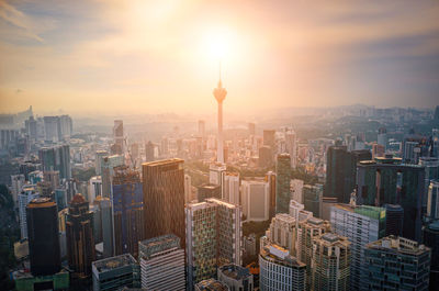 Aerial view of buildings in city during sunset