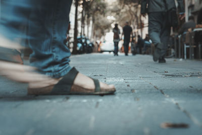 Low section of people walking on street