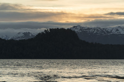 Scenic view of sea and mountains against sky during sunset