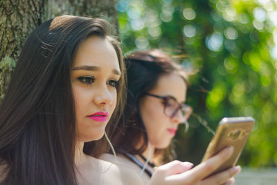 Close-up of young woman using smart phone outdoors