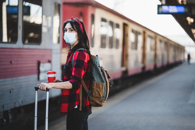 Woman standing at railroad station
