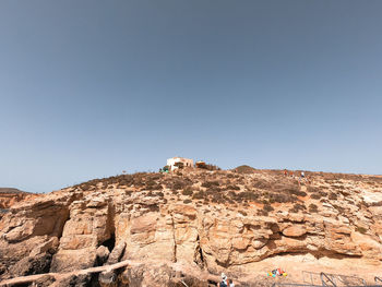 Low angle view of rock formations against clear blue sky