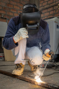 Man welding metal in a workshop in latin america