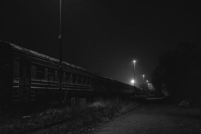 Illuminated street lights against sky at night