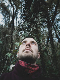 Portrait of young man looking away in forest