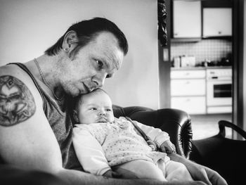 Father with baby girl sitting on sofa at home