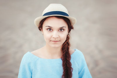Close-up portrait of woman wearing hat at beach
