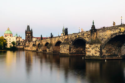 Arch bridge over river against clear sky