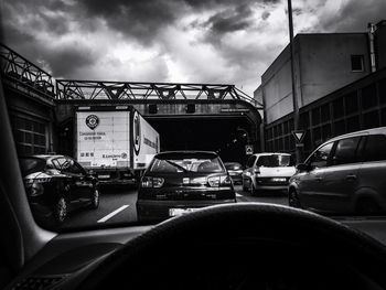 Cars on city street against sky