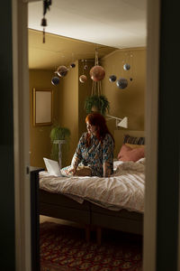 Woman on bed using laptop