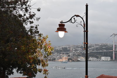 Street light by building against sky