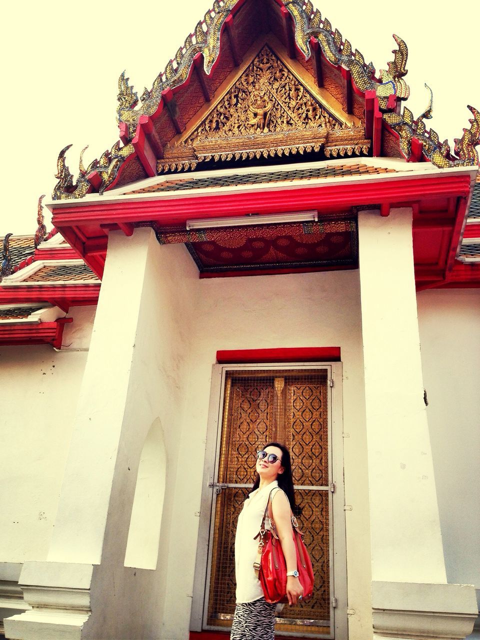 architecture, built structure, building exterior, low angle view, religion, temple - building, place of worship, spirituality, lifestyles, casual clothing, red, steps, sky, roof, leisure activity, standing, day