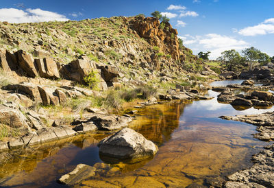 Scenic view of rock formation in water against sky