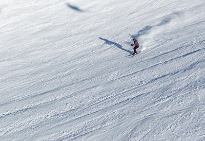 Aerial view of woman skiing on snowcapped mountain