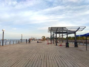 Pier on beach against sky