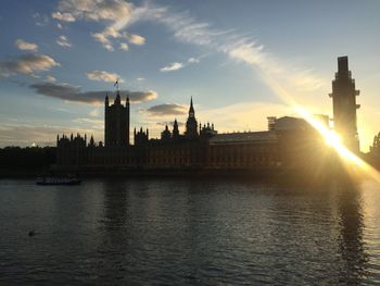 Buildings at waterfront during sunset