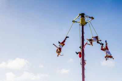 Low angle view of friends against clear sky