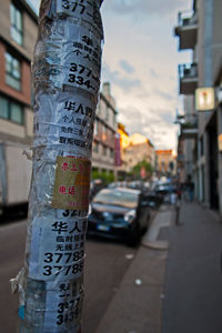 Close-up of pamphlets on pole at sidewalk