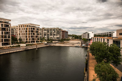 River by buildings against sky in city