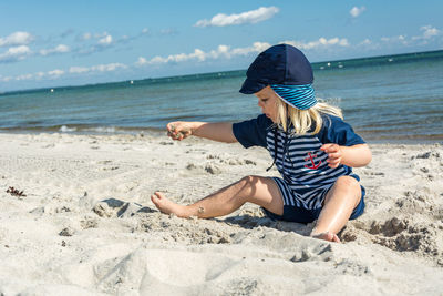 Carefree girl playing with sand at beach