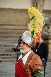 Portrait of man wearing multi colored feathers