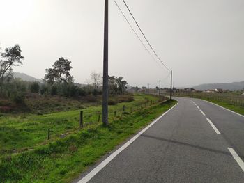 Road amidst plants and trees against sky