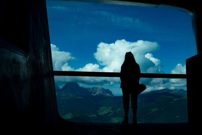 Silhouette man standing by sea against sky
