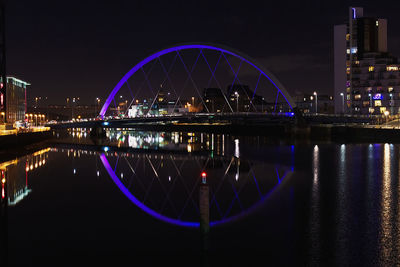 Illuminated cityscape against sky at night