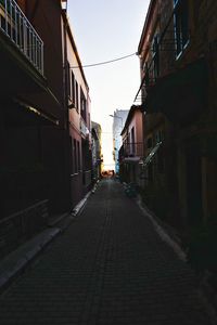 Alley amidst street in city against sky