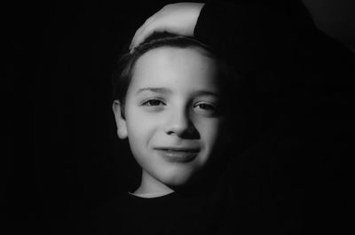 Portrait of boy against black background