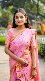 Portrait of smiling young woman standing outdoors