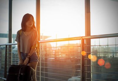 Woman standing by window at airport