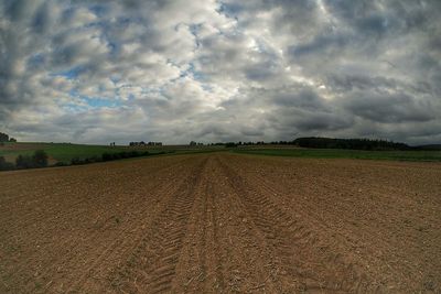 Scenic view of field against cloudy sky