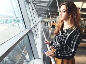 Thoughtful young woman standing airport terminal