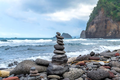 Column of balanced stones on the rocky shore of the ocean on the hawaiian island