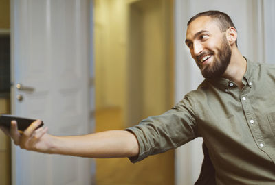 Happy businessman passing mobile phone in office