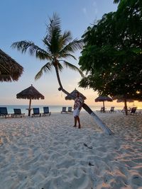 Rear view of people on beach against sky