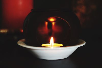Close-up of lit tea light candle on table