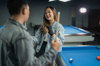 Portrait of young woman playing pool