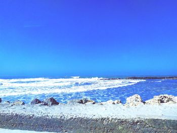 Scenic view of sea against clear blue sky