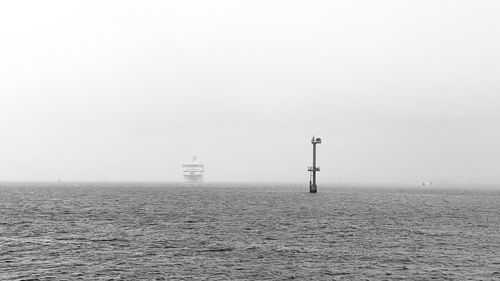 Scenic view of sea against sky with a ferry appearing from fog