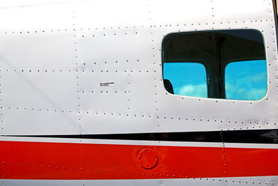 Close-up of airplane window against sky